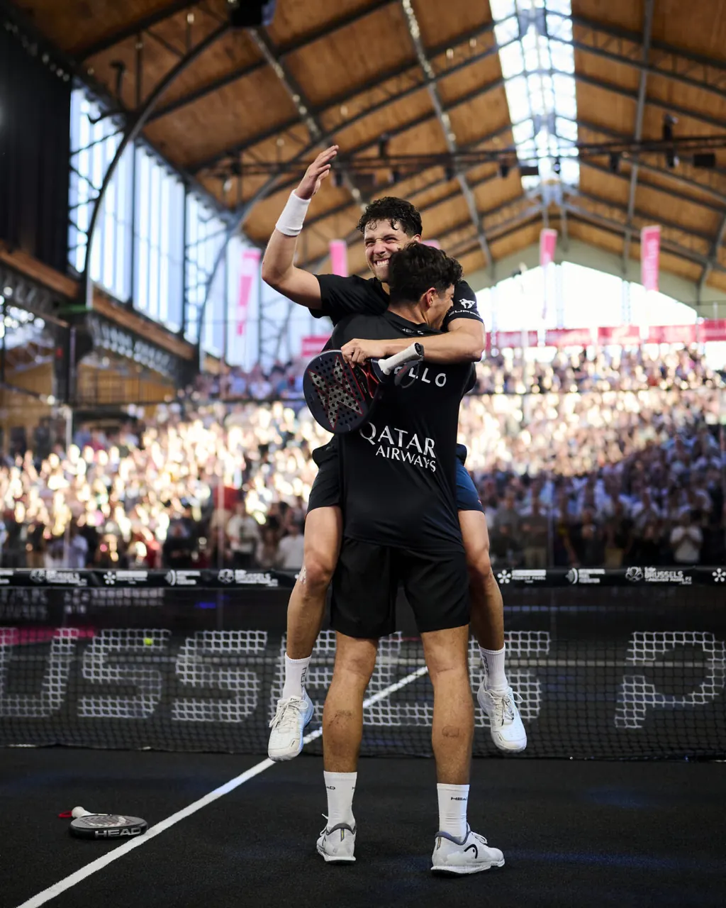 A player serving with a padel racket during Brussels Premier Padel
